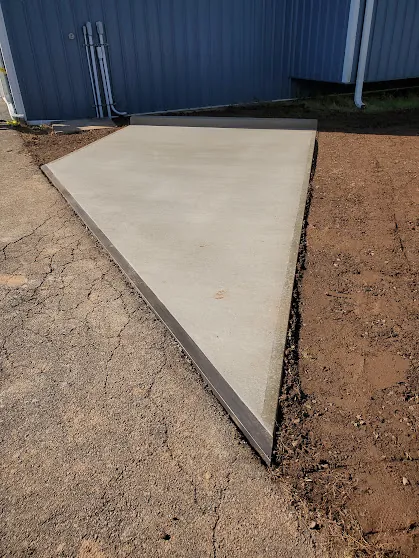 Completed concrete apron beside a blue aircraft hangar at Somerset Airport