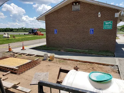 Concrete walkway improvements in progress around a Somerset Airport building